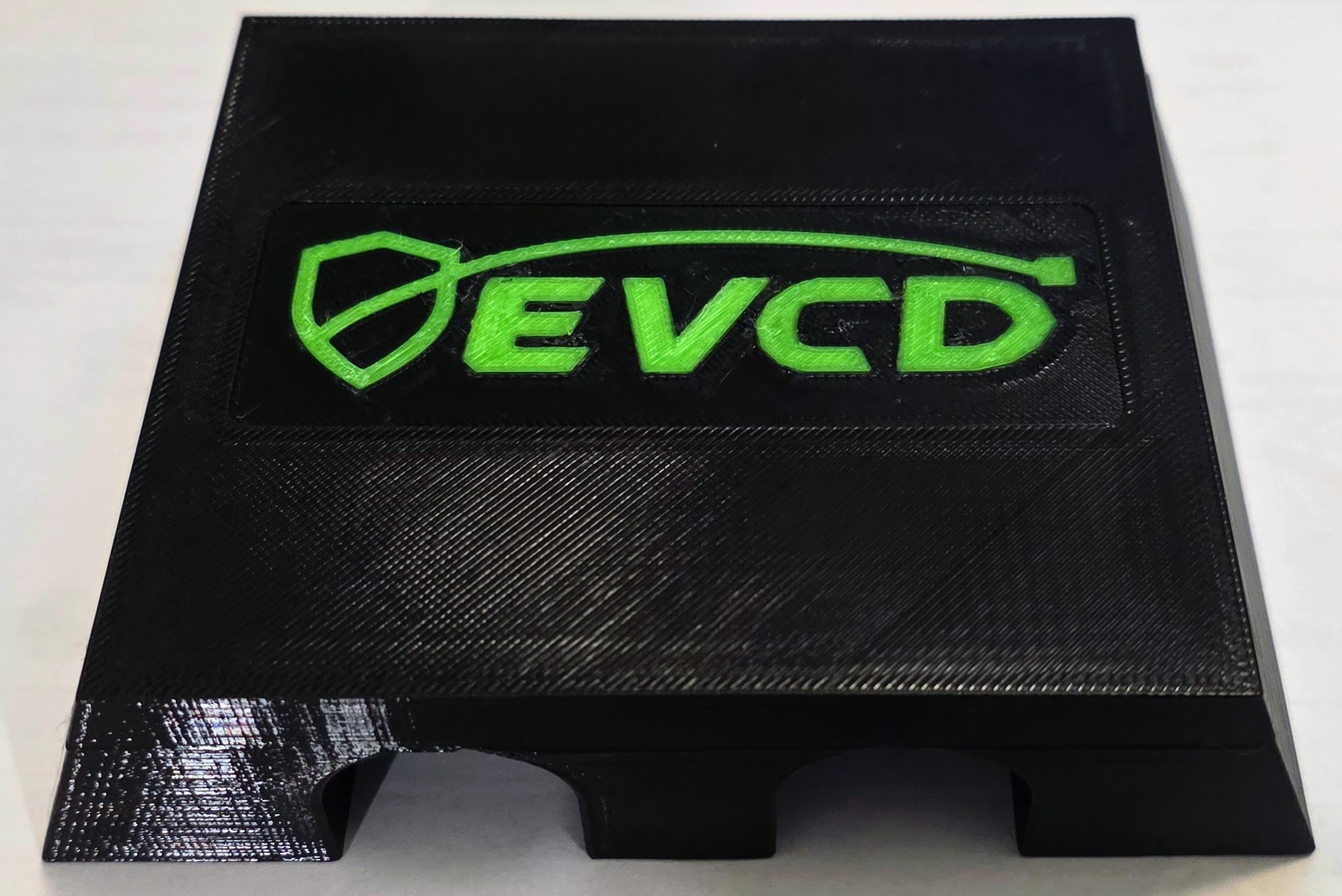 Real black PETG EVCD Ridge Trio with raised green shield-and-cable logo and three cable channels